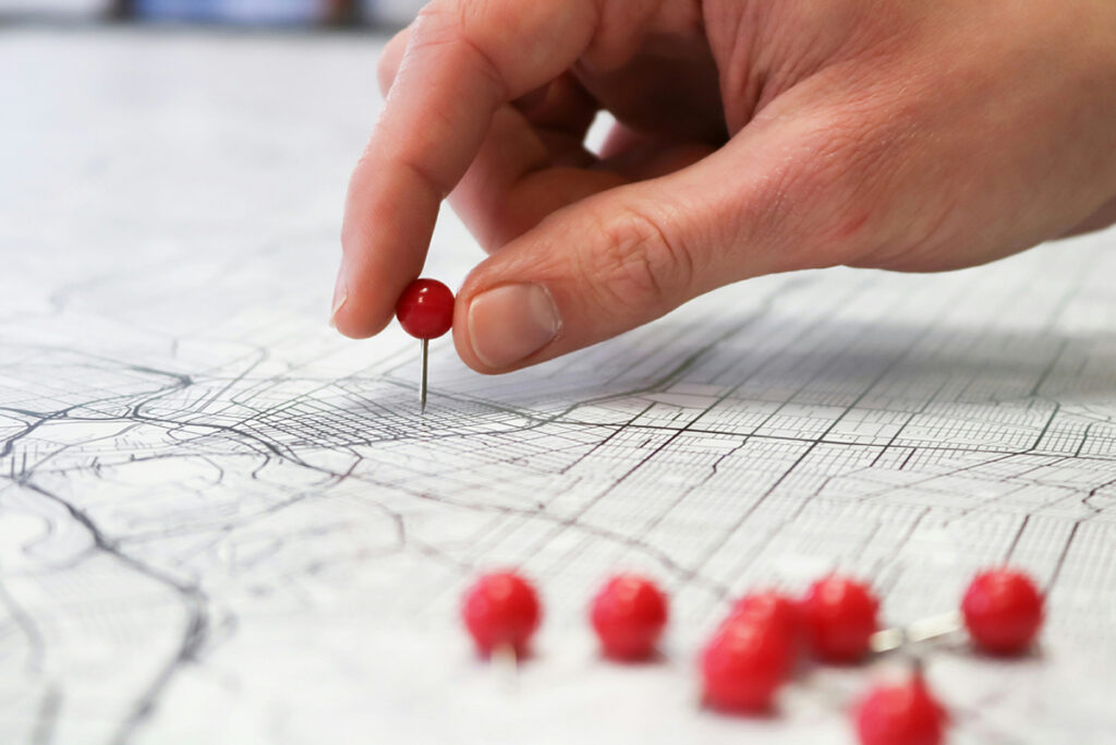 A person putting a pin in a map