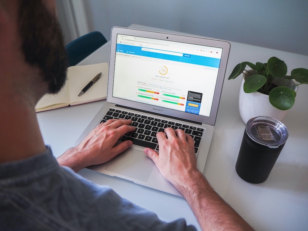 A person sitting at their laptop doing a speed test using a Google tool